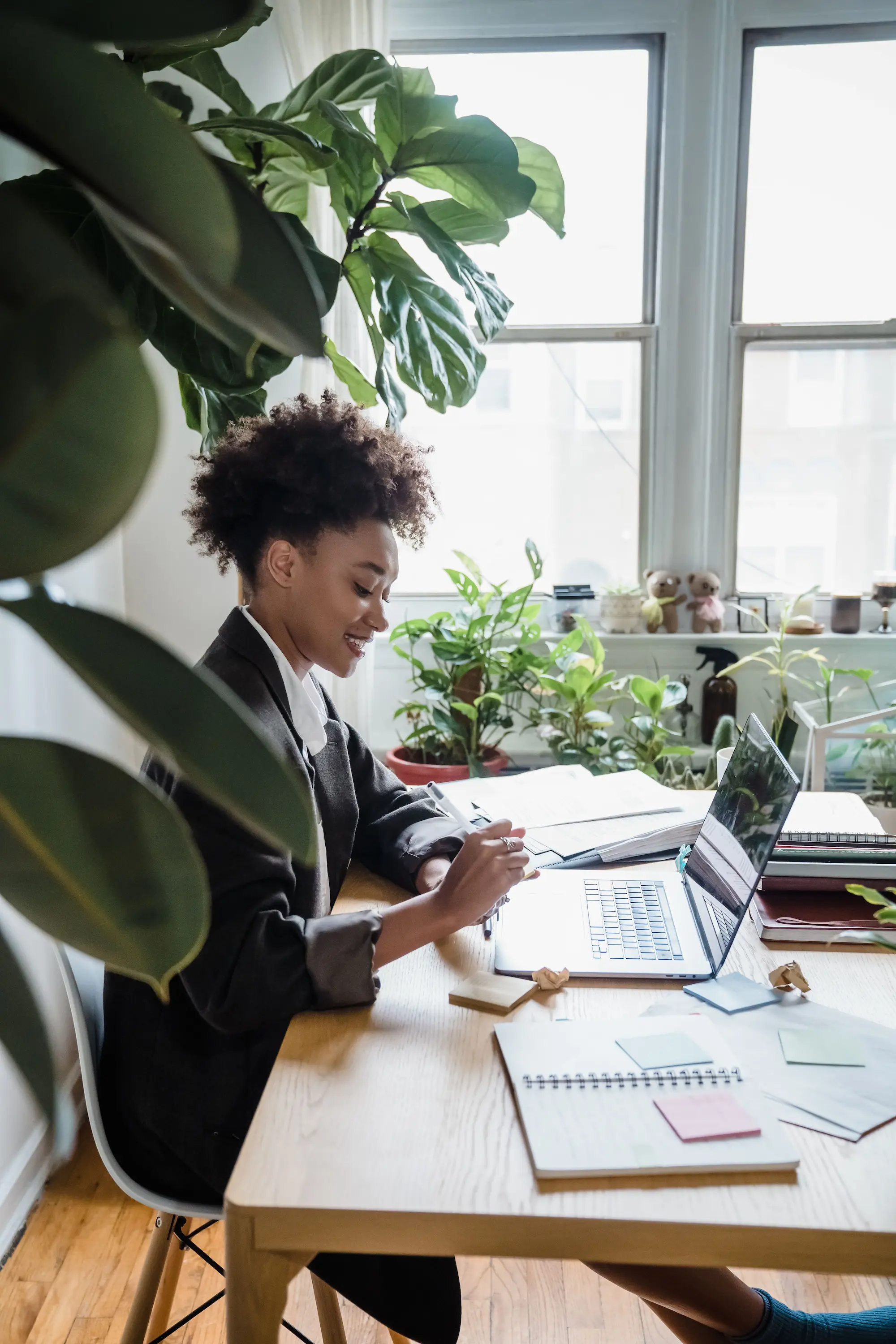 A business owner reviewing notes and working at a laptop